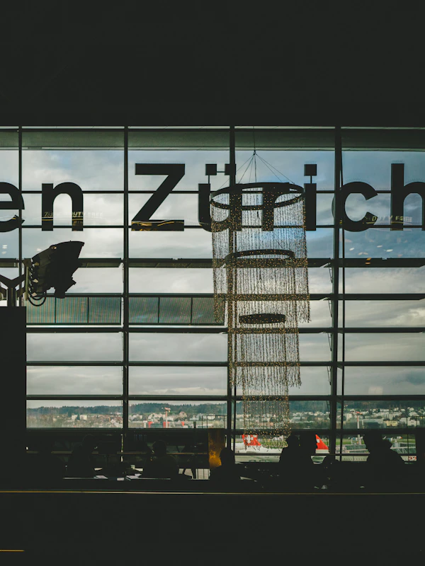 Zurich Airport (ZRH) arrivals hall - Professional airport transfer chauffeur meeting passenger with name sign